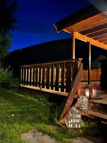 Un porche de madera con terraza por la noche. en Hytte i vakre Reisadalen, en Storslett
