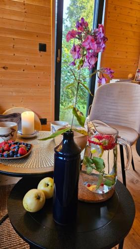 a table with a candle and a vase of flowers at Mājīgs dzīvoklis netālu no jūras in Skulte