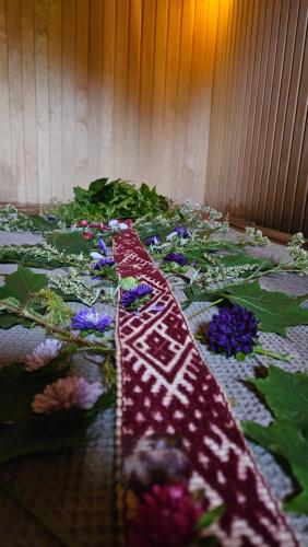 a quilt with flowers on top of a table at Mājīgs dzīvoklis netālu no jūras in Skulte