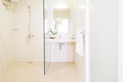 a bathroom with a shower and a sink at Bali True Living in Denpasar