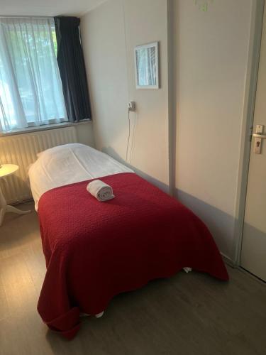 a bedroom with a bed with a red blanket at Hotel-Eetcafé d'Olde Heerd in Balkbrug