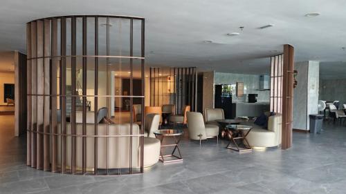 un hall avec des chaises et des tables dans un bâtiment dans l'établissement Brand NEW Modern Cozy Retreats 3BR2B2P for 6, à Batu Kawan