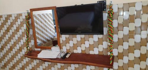 a flat screen tv on a wall with a mirror at NHÀ NGHỈ VIỆT NGA in Ha Tien