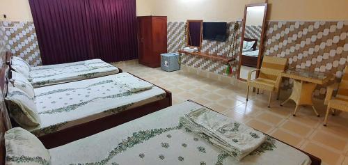 a hotel room with two beds and a mirror at NHÀ NGHỈ VIỆT NGA in Ha Tien