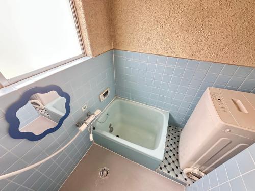 a blue tiled bathroom with a toilet and a sink at Minato House 101 in Fukuoka