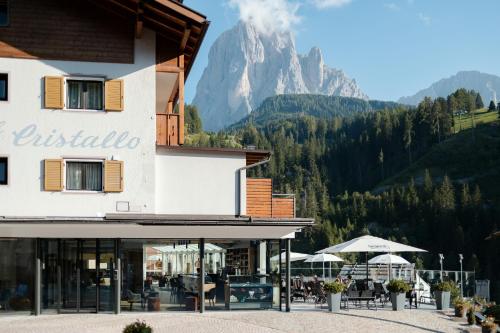 a building with a mountain in the background at Hotel Cristallo in Santa Cristina in Val Gardena