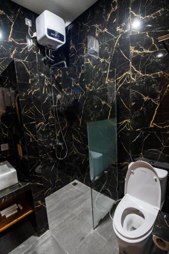 a bathroom with a black and gold marble wall at Umanisa Villas in Gianyar