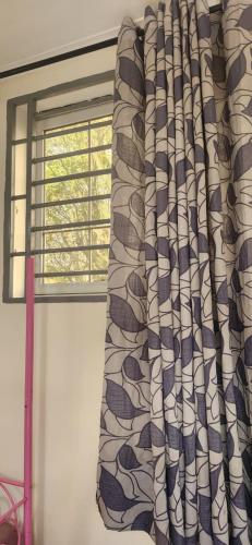 a window with a curtain in a room at Zuri Zen Villa in Dar es Salaam