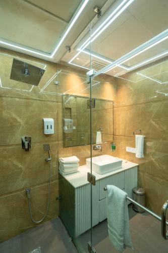 a bathroom with a shower and a sink and a mirror at GAJRAULA SUKHDEV DHABA and RESORT 