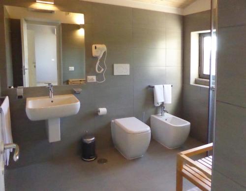 a bathroom with a sink and a toilet and a mirror at Pietre di Fiume in Apice