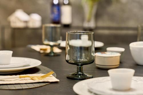 a wooden table with glasses and plates on it at Soyo Stay SEOUL, Free car driving service to Korean Folk Village, Everland in Seoul