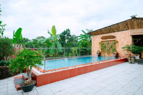 a swimming pool in a yard with a building at Homestay Thùy Dương 1 in Cai Be