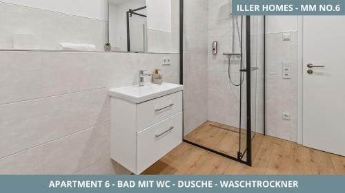 Un baño blanco con lavabo y ducha. en Iller Homes Memmingen - 3 x Moderne Fewos mit Terrasse für bis zu 7 Pers mit Parkplätzen, en Memmingen