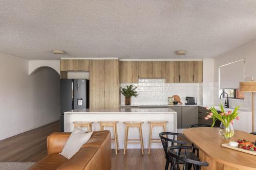 a kitchen and living room with a couch and a table at Ali's Waterfront Escape - Relaxing Getaway, Near Kirra Beach in Tweed Heads