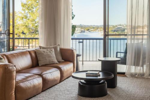 a living room with a couch and a large window at Ali's Waterfront Escape - Relaxing Getaway, Near Kirra Beach in Tweed Heads