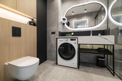 a bathroom with a washing machine and a mirror at Wings Plaza in Kraków