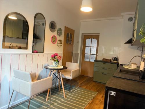 Una cocina con una mesa y dos sillas y un fregadero. en FABRYCZNA Przytulność, en Zielona Góra