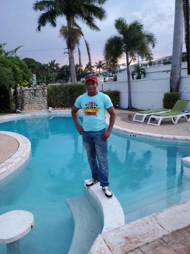 a man standing on a ledge in front of a swimming pool at Bayview Luxury Retreat 