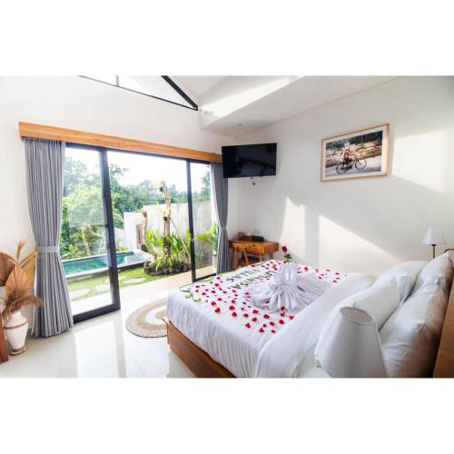 a bedroom with a bed and a large window at Umanisa Villas in Gianyar