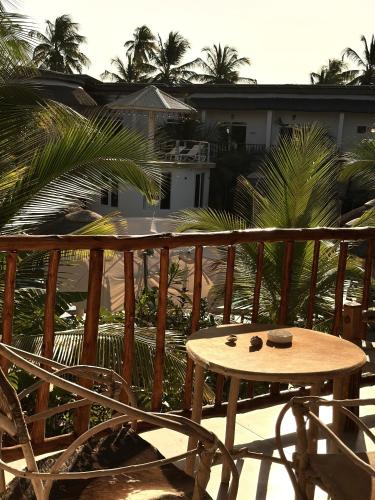 a table and chairs on a balcony with palm trees at Olzadia Boutique Hotel in Michamvi