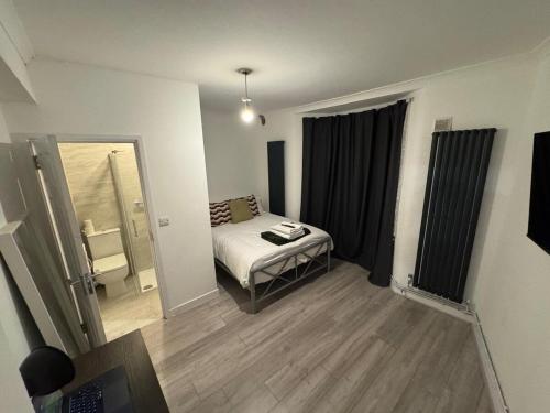 a small room with a bed and a mirror at 38LYW Large Ensuite Room - Stratford, London in London