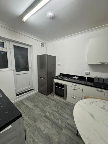a kitchen with a stove and a refrigerator at 38LYW Large Ensuite Room - Stratford, London in London