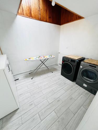 a laundry room with a washing machine and a table at L amienoise in Longueau