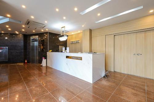 eine Lobby mit einer Theke in der Mitte eines Zimmers in der Unterkunft Brown Dote Hotel Geunpohang in Geoje