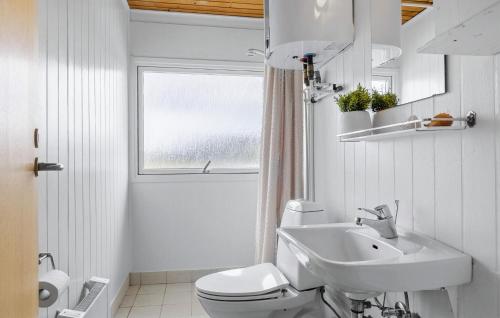 a white bathroom with a toilet and a sink at 4 Bedroom Beautiful Home In Thisted in Torsted