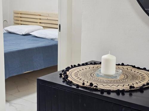 a candle on top of a dresser with a bed at Hadas in the desert in Yeroẖam