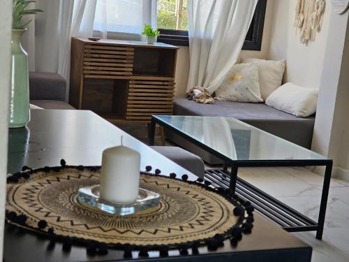 a living room with a candle on a table at Hadas in the desert in Yeroẖam