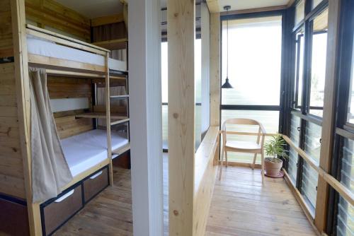 two bunk beds in a room with a table and a chair at Vessel Hostel in San Juan