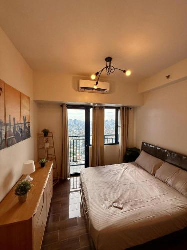 a bedroom with a bed and a large window at Makati Luxury Hotel Room Balcony Air Residence in Sampong