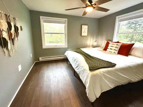 a bedroom with a large bed and a ceiling fan at Pocono Mountain Escape - Steps to Lake- Hot Tub - Games- 9 Mins to Ski Slopes! in Long Pond