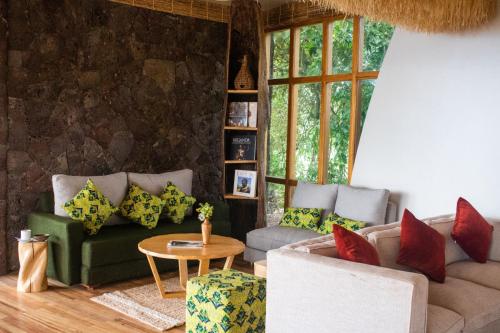 a living room with two couches and a table at Ndere Echifuuha Resort in Kisoro