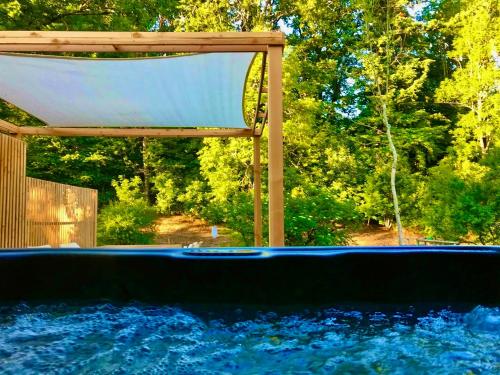 an empty swimming pool with a canopy and water at Gezellige Typisch Ardense woning met jacuzzi en grote afgesloten tuin in prachtige omgeving in Houffalize