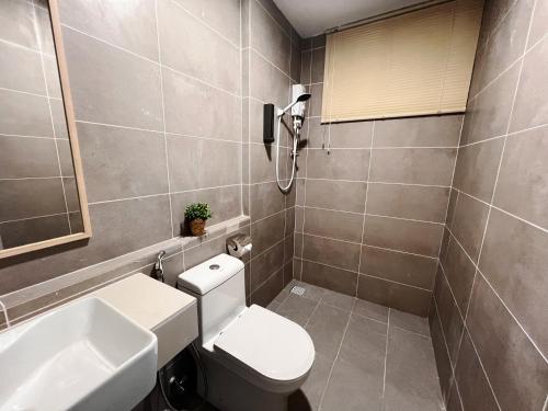 a bathroom with a toilet and a sink at Your Comfy Samarahan Retreat in Kuching