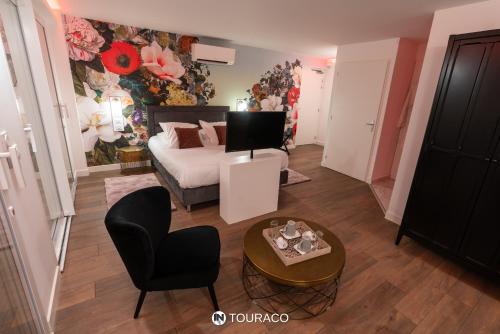 a bedroom with a bed and a table and a chair at Touraco in Villars-les-Dombes