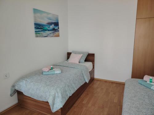 a bedroom with two beds and a picture on the wall at Apartments Xenia Krk in Krk