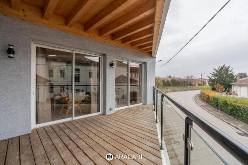 a wooden deck with glass doors on a house at Aracari in Villars-les-Dombes