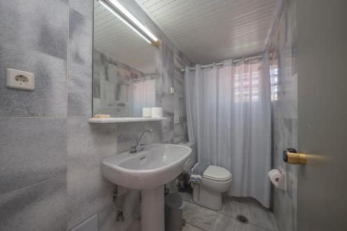 ein weißes Bad mit einem Waschbecken und einem WC in der Unterkunft Manias Hotel Apartments in Agia Marina