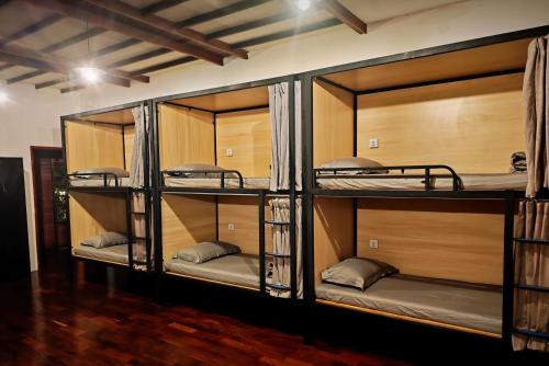 a room with three bunk beds in a room at Wood Wood Hostel in Vientiane