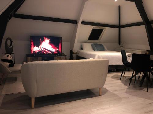 a living room with a couch and a bed and a tv at Atico in Rotterdam