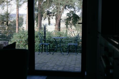 a door leading to a patio with a table and chairs at The Observatory Annexe in Dorking