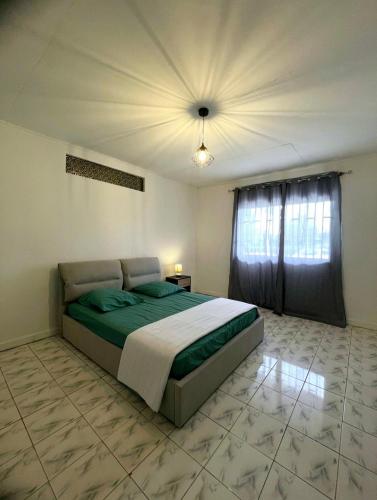 a bedroom with a bed and a ceiling at La villa fruitier Cavalier in Saint-Laurent du Maroni