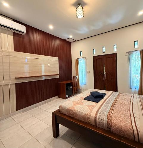 a bedroom with a bed and a tv in it at Tregge Surf Camp Uluwatu in Uluwatu