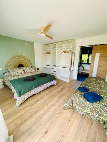 a bedroom with two beds and a ceiling fan at La Logette in Les Petites-Loges