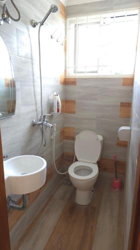 a bathroom with a toilet and a sink at Serenity Gardens,pool retreat, Kigamboni in Dar es Salaam