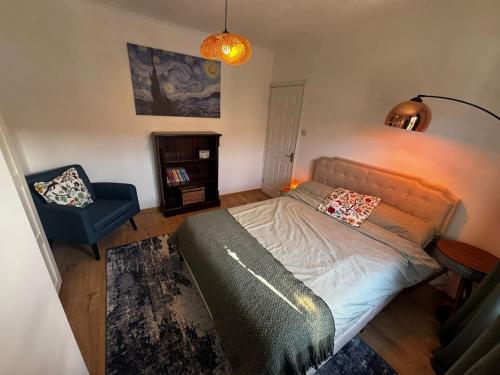 Un pequeño dormitorio con una cama y una silla. en Selene Apartment in Heart of Glastonbury, en Glastonbury