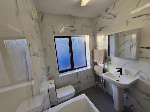 Un baño blanco con lavabo y espejo. en Selene Apartment in Heart of Glastonbury, en Glastonbury